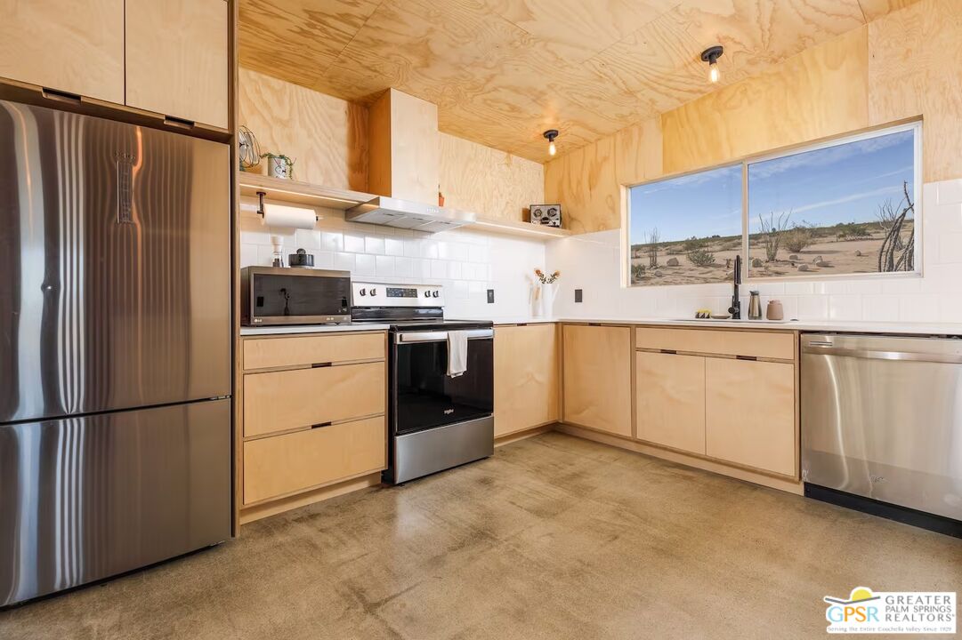 4619 Kickapoo Trail Landers, CA 92285 - Photo 13 of 55 a kitchen with stainless steel appliances granite countertop a sink stove and refrigerator