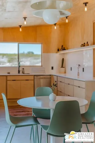 a kitchen with a table chairs sink and cabinets