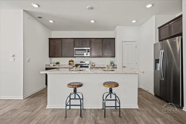 a kitchen with kitchen island white cabinets appliances and a center island