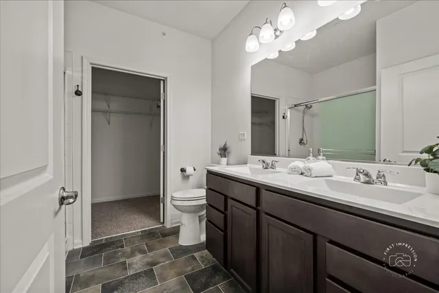 a bathroom with a double vanity sink mirror and toilet