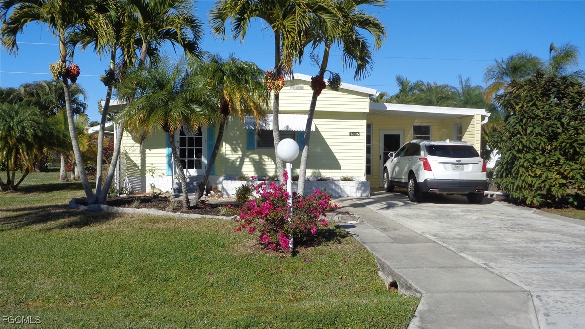 7696 Helen Road Bokeelia, FL 33922 - Photo 2 of 45 a front view of a house with a garden and tree