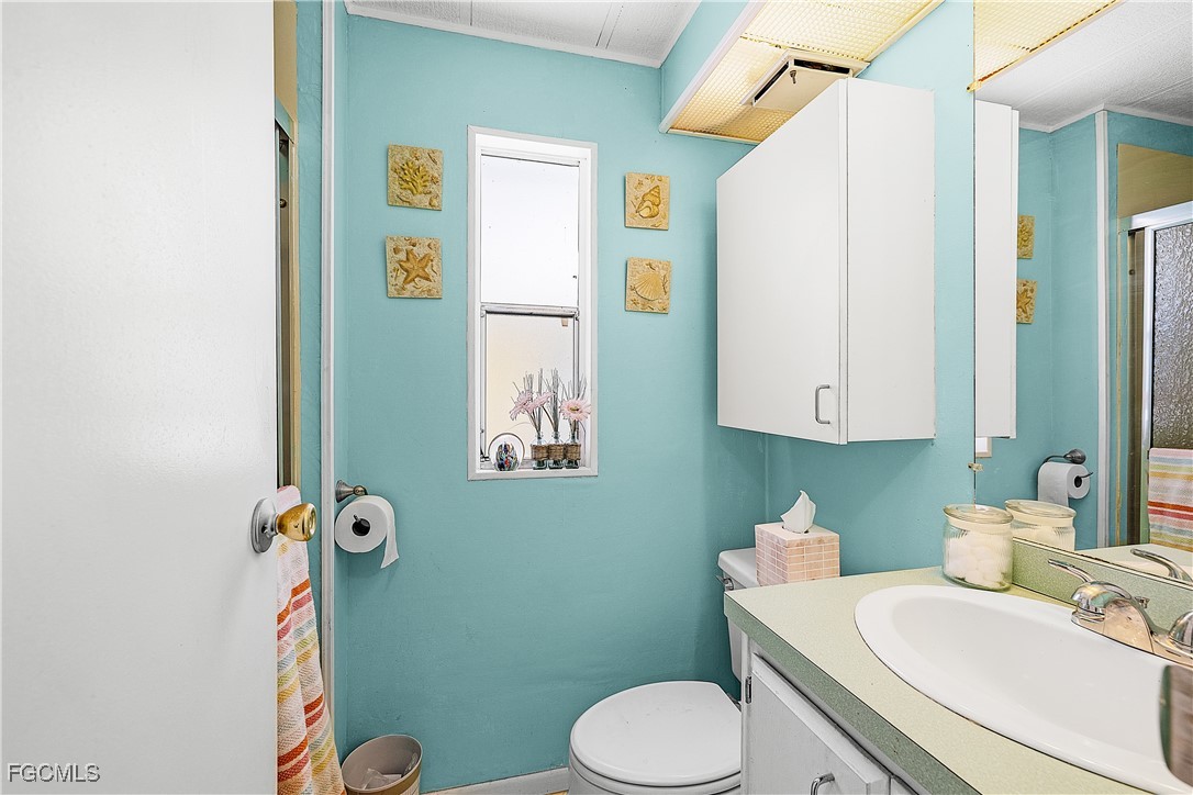 7696 Helen Road Bokeelia, FL 33922 - Photo 21 of 45 a bathroom with a sink a toilet and mirror