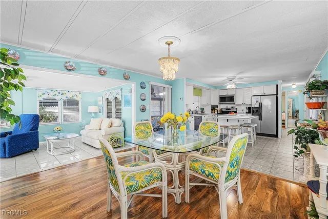 a dining room with furniture a chandelier and wooden floor