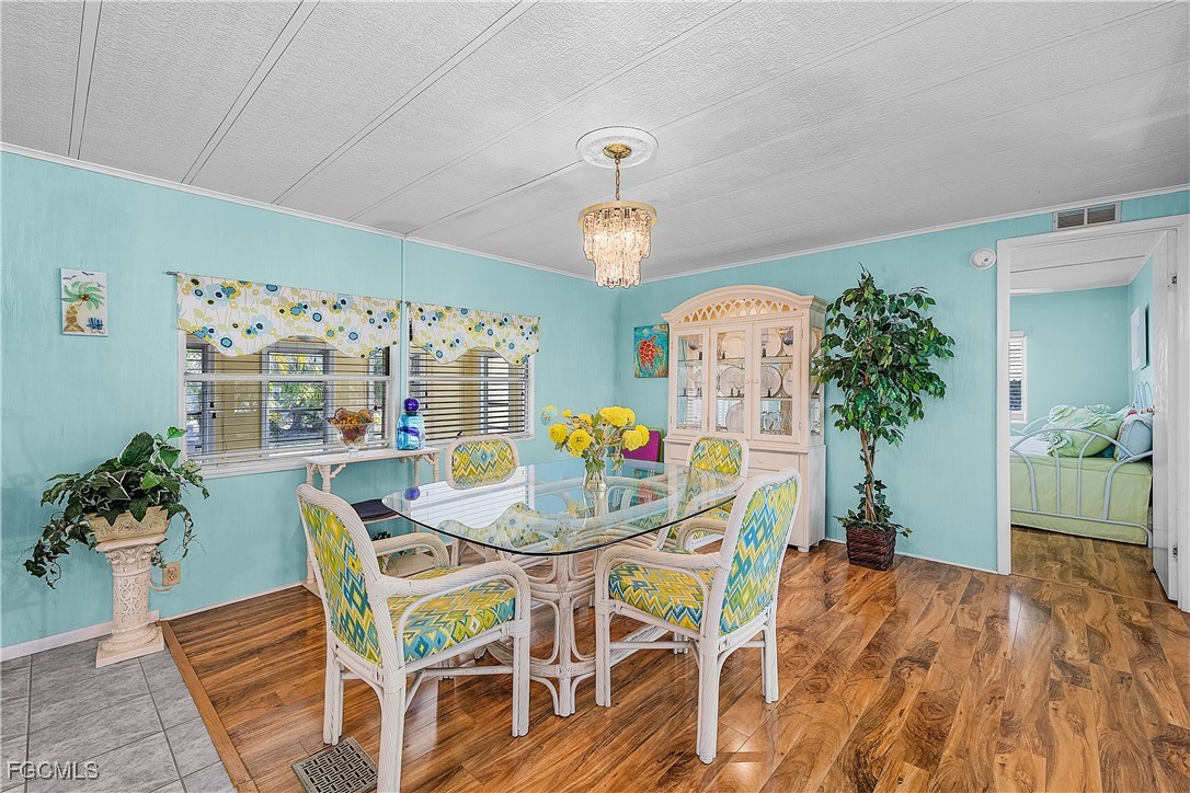 7696 Helen Road Bokeelia, FL 33922 - Photo 25 of 45 a view of a dining room with furniture and wooden floor