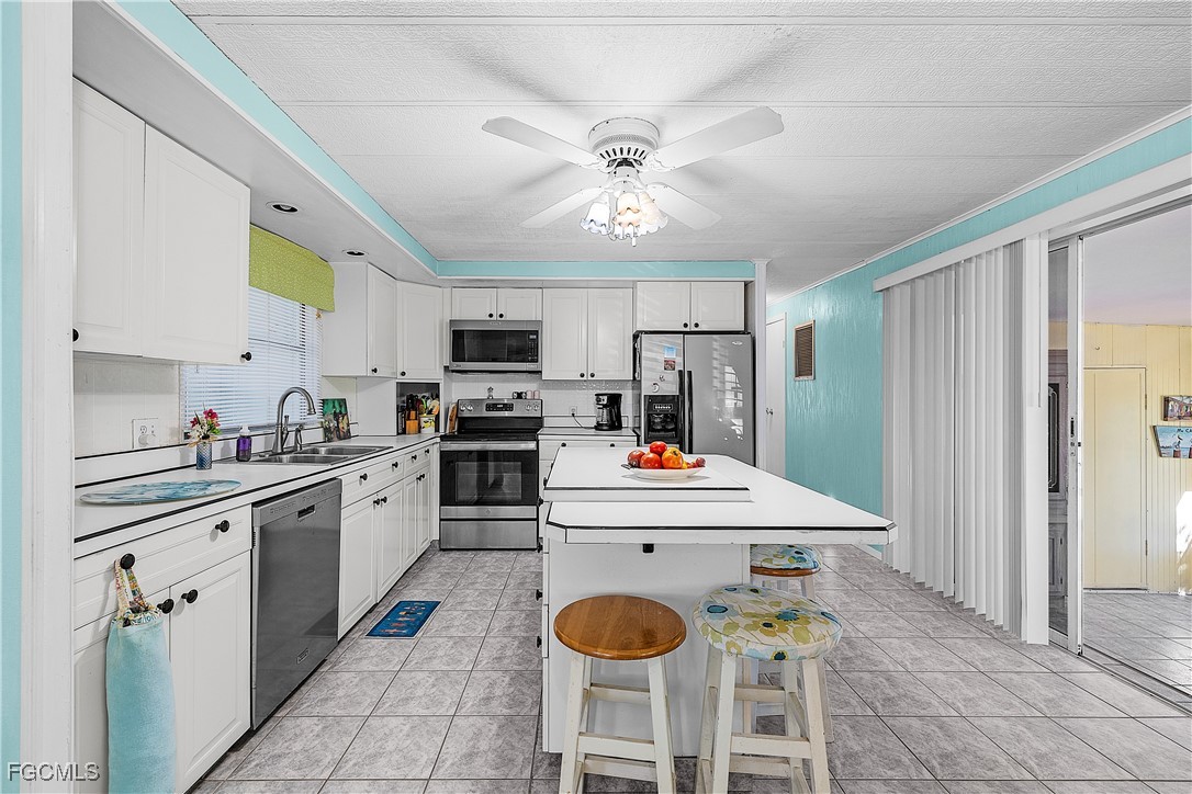 7696 Helen Road Bokeelia, FL 33922 - Photo 27 of 45 a kitchen with cabinets a sink and stainless steel appliances