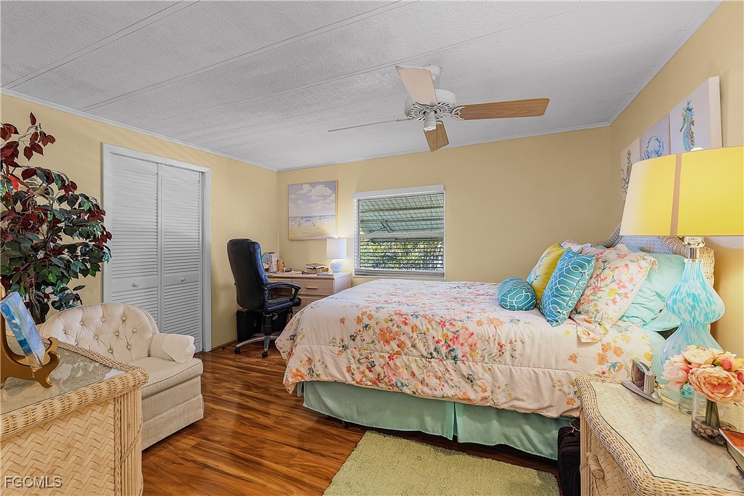 7696 Helen Road Bokeelia, FL 33922 - Photo 32 of 45 a bedroom with a bed and wooden floor