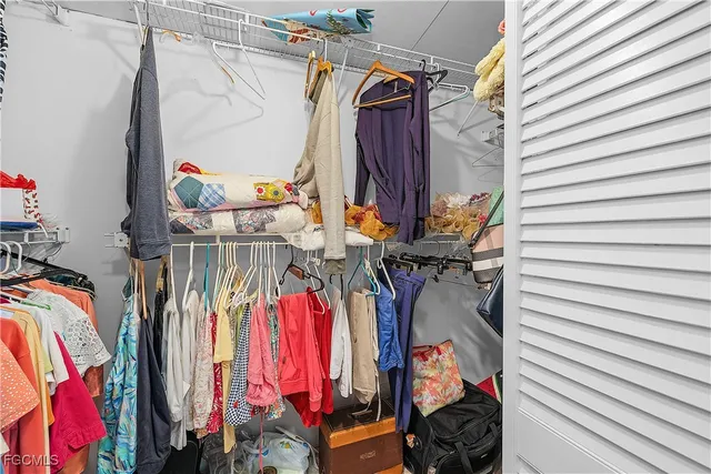 a view of walk in closet with clothes and shoes