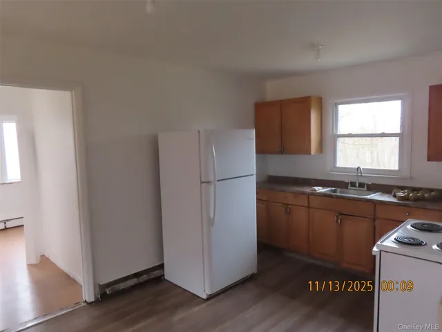 a kitchen with granite countertop a refrigerator and a sink