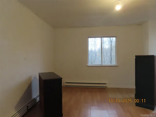 a view of a small space with wooden floor and a window