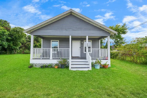 a view of a house with a small yard and wooden fence
