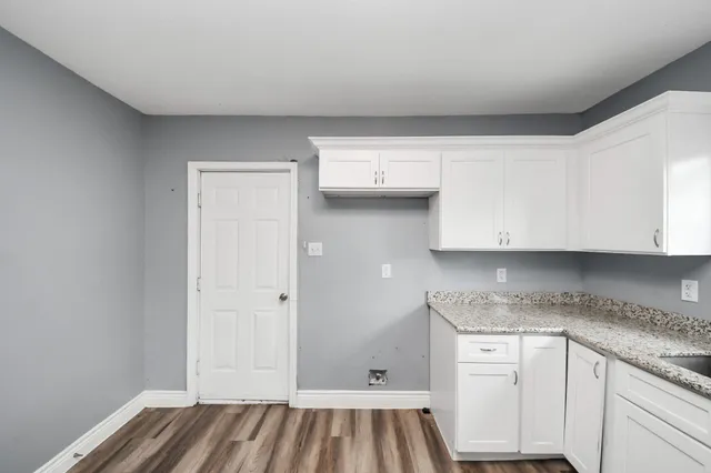 a kitchen with granite countertop a sink and cabinets