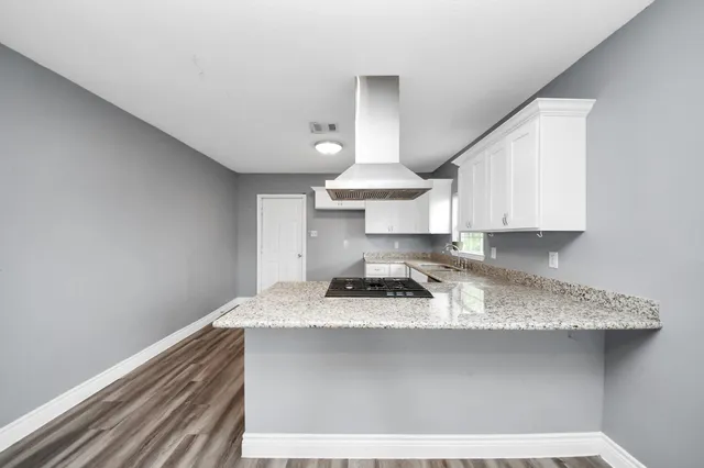 a kitchen with a sink cabinets and a wooden floor
