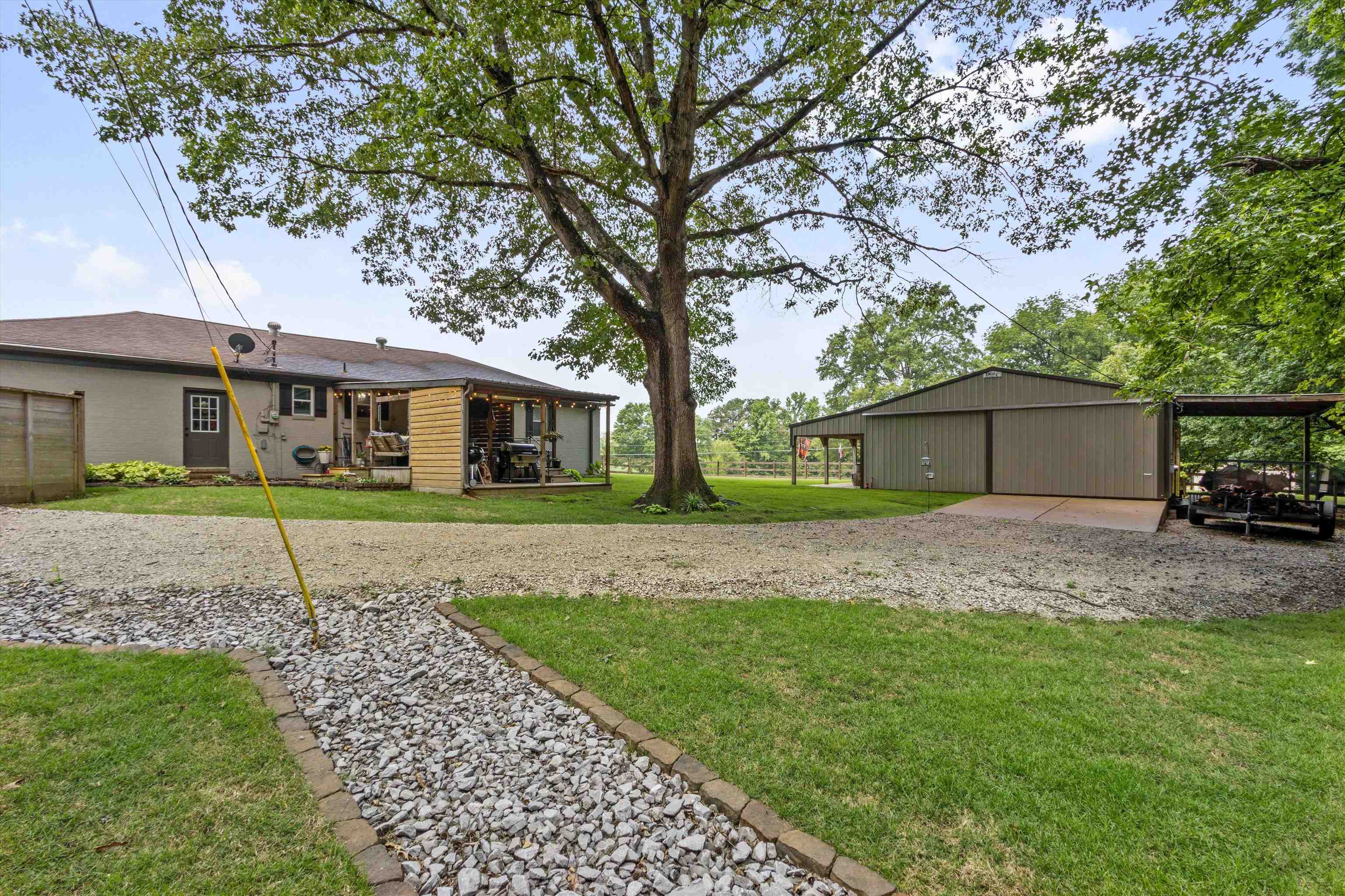 4500 Drummonds Road Drummonds, TN 38023 - Photo 25 of 29 a front view of a house with a garden and trees