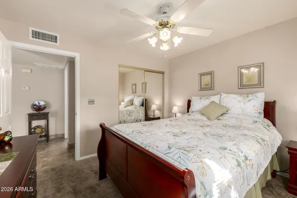 a spacious bedroom with a bed and dresser