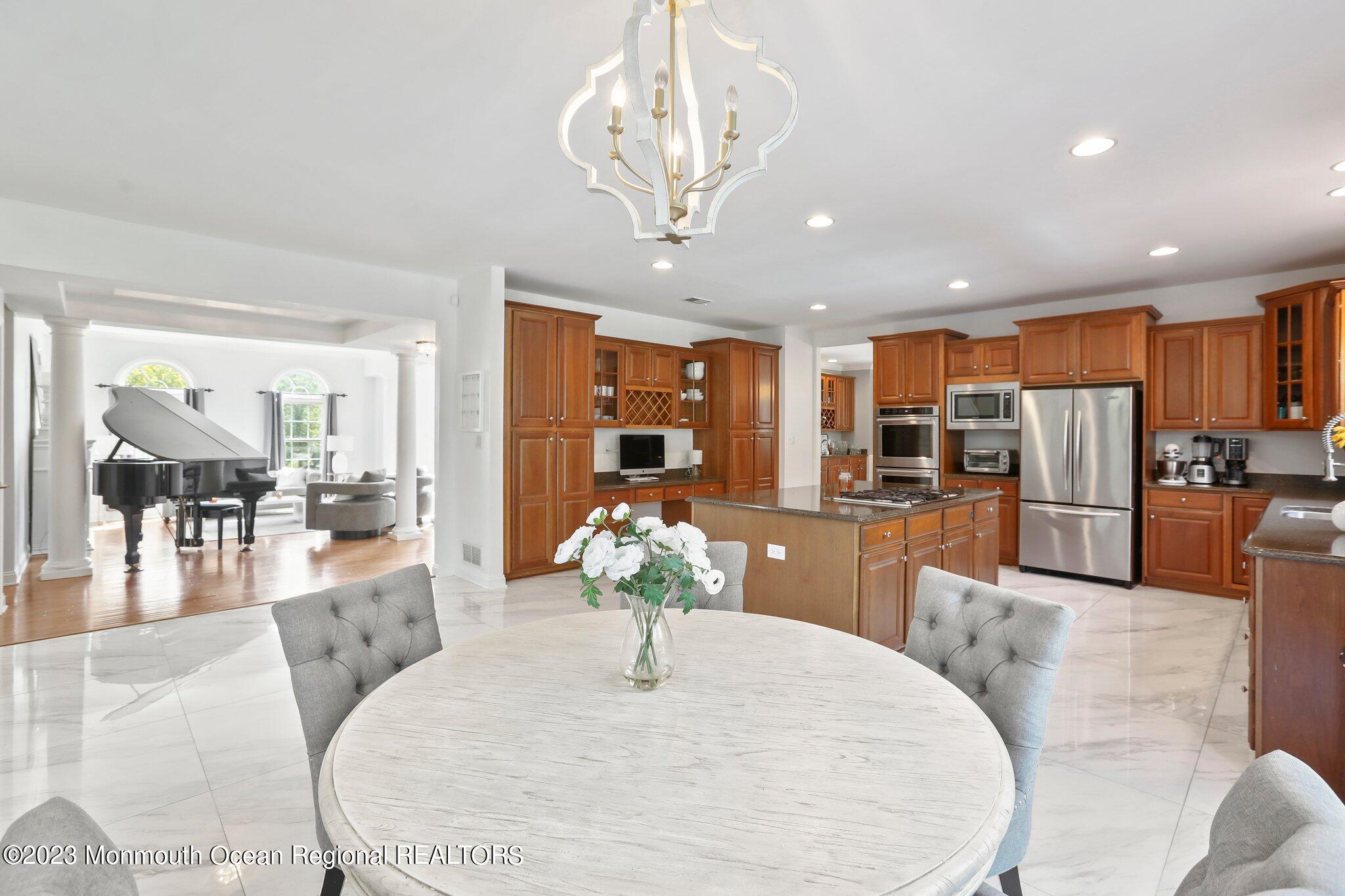 2 Wilson Boulevard Jackson, NJ 08527 - Photo 15 of 41 a large kitchen with stainless steel appliances kitchen island granite countertop a refrigerator a stove a sink a dining table and chairs with wooden floor