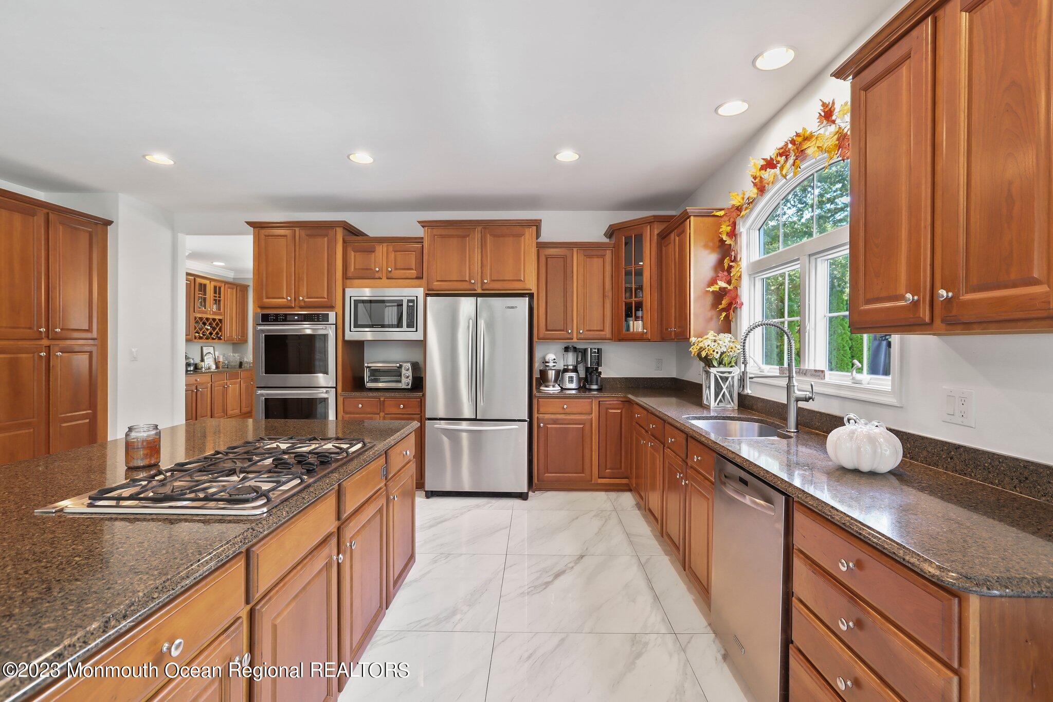 2 Wilson Boulevard Jackson, NJ 08527 - Photo 17 of 41 a kitchen with refrigerator a stove and a wooden cabinets