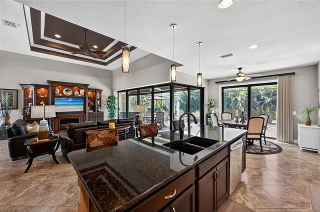 a living room with furniture a flat screen tv and floor to ceiling window