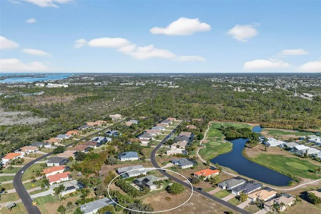 an aerial view of a houses with a lake and city view