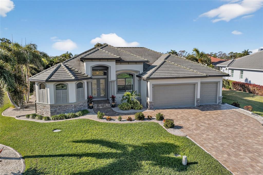 8 Windward Road Placida, FL 33946 - Photo 6 of 47 a front view of a house with a yard and garage