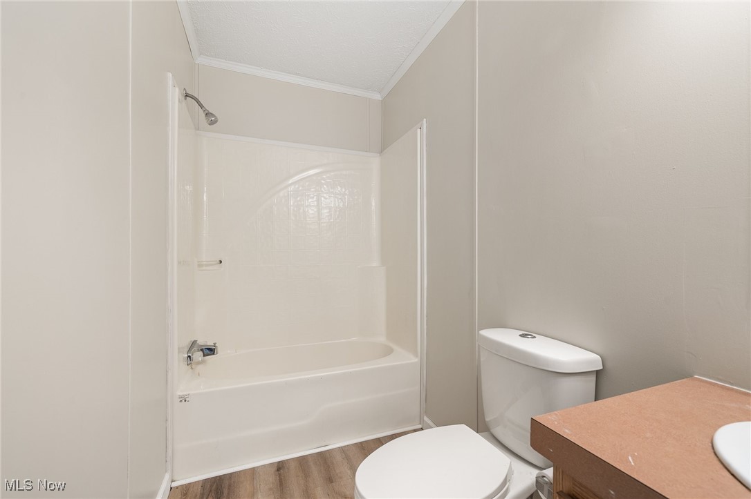 4838 Angling Rd Extension Wooster, OH 44691 - Photo 27 of 39 Bathroom with wood finished floors, crown molding, vanity, and bathing tub / shower combination