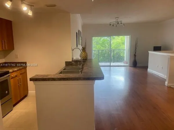 a kitchen with stainless steel appliances granite countertop a stove a sink and a refrigerator