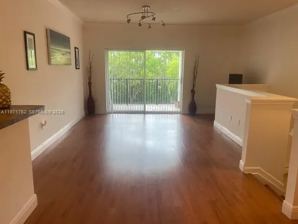 a view of a room with wooden floor and a window