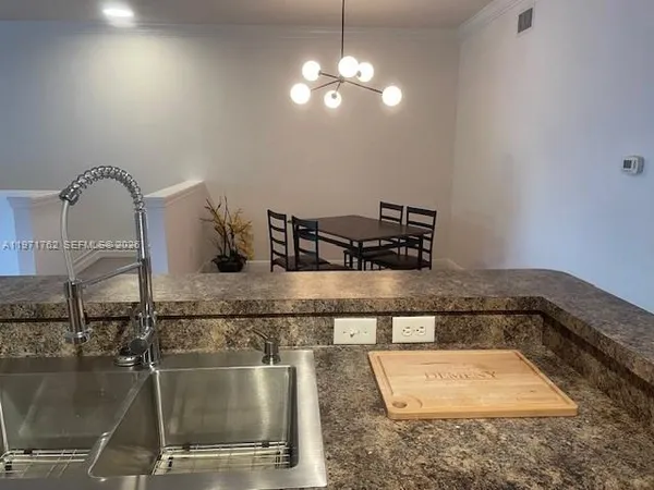 a kitchen with a sink a counter space and cabinets