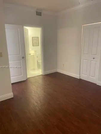 an empty room with wooden floor and closet