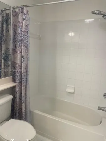 a white toilet sitting next to a bath tub
