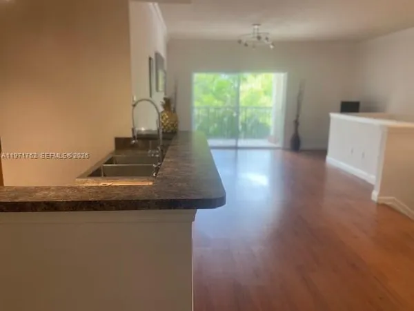 a view of a kitchen with furniture and wooden floor