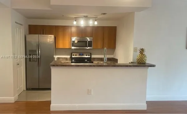 a kitchen with kitchen island stainless steel appliances a sink and refrigerator