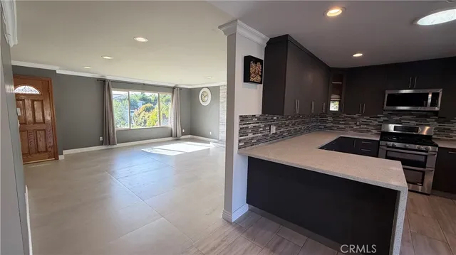 a kitchen with stainless steel appliances a stove a sink a microwave a refrigerator and cabinets