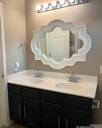 a bathroom with a double vanity sink and a mirror