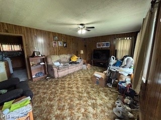 5806 Risher Road Leavittsburg, OH 44430 - Photo 4 of 18 Living area featuring a ceiling fan, carpet floors, a textured ceiling, and wood walls