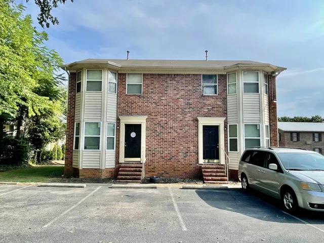 a car parked in front of a brick house