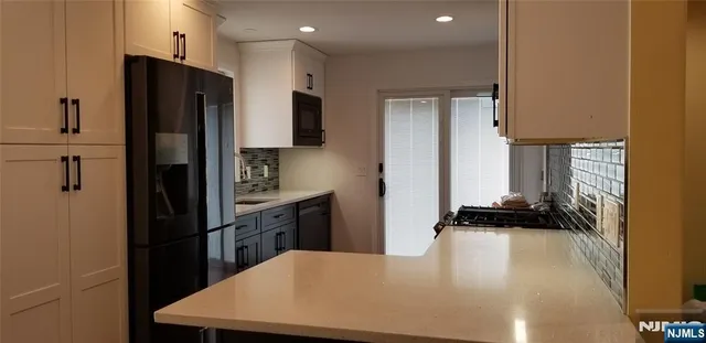 a kitchen with a refrigerator and a stove top oven