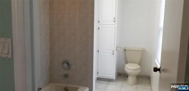 a bathroom with a granite countertop toilet and a shower