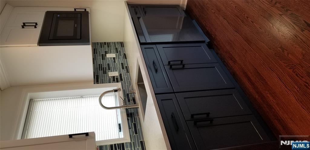 374 East Midland Avenue Paramus, NJ 07652 - Photo 10 of 12 a kitchen with stainless steel appliances wooden cabinets and a wooden floor