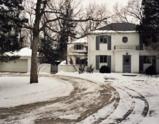 a front view of a house with a yard covered in snow