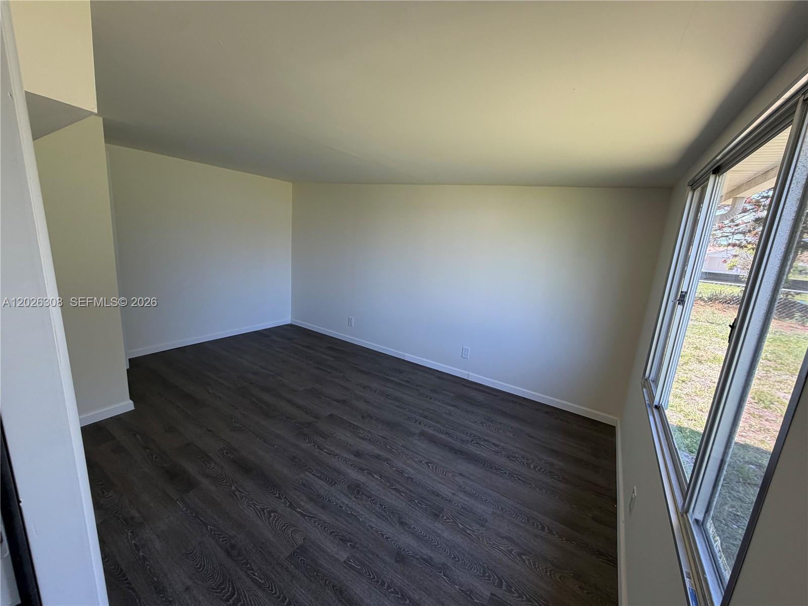653 Atlas Avenue Northeast Palm Bay, FL 32905 - Photo 16 of 22 an empty room with wooden floor and windows