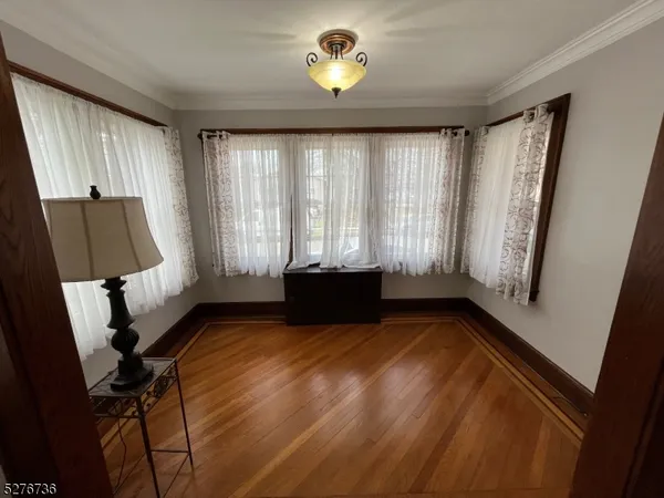 a view of a room with window and hardwood floor