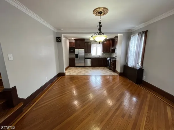 a view of kitchen and hall with wooden floor