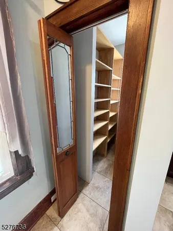 a view of closet with wooden floor and stairs
