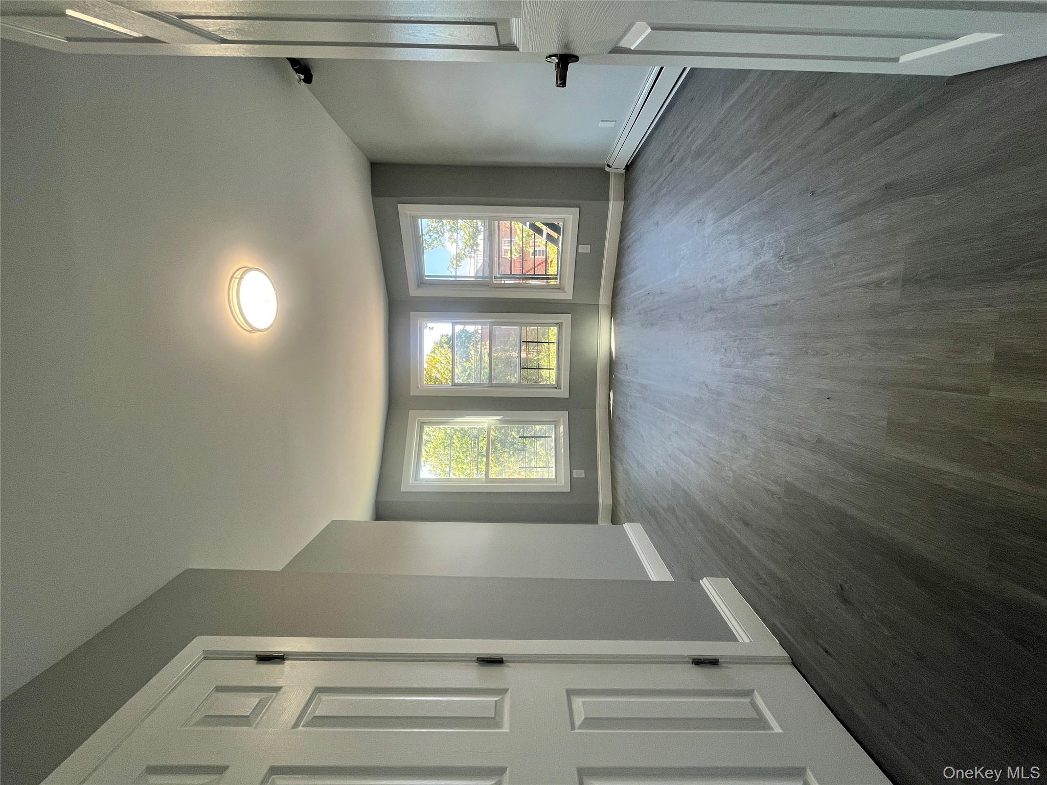 Undisclosed Address Yonkers, NY 10701 - Photo 4 of 10 an empty room with wooden floor and windows