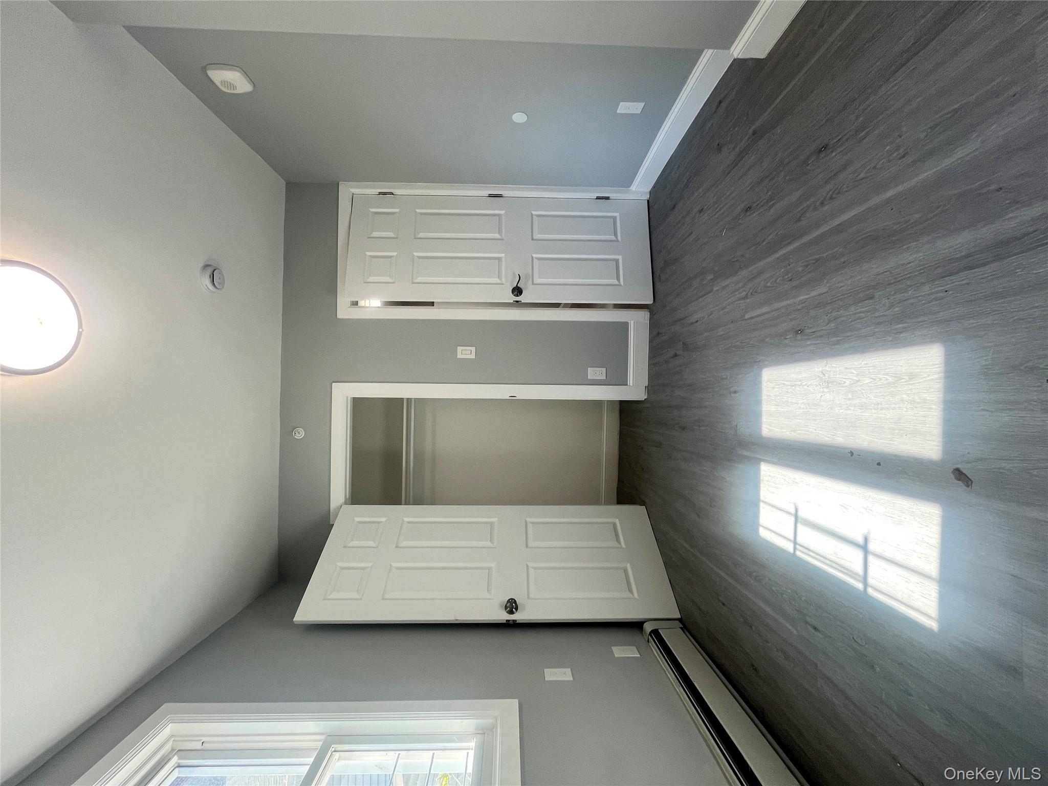 Undisclosed Address Yonkers, NY 10701 - Photo 9 of 10 an empty room with wooden floor and windows