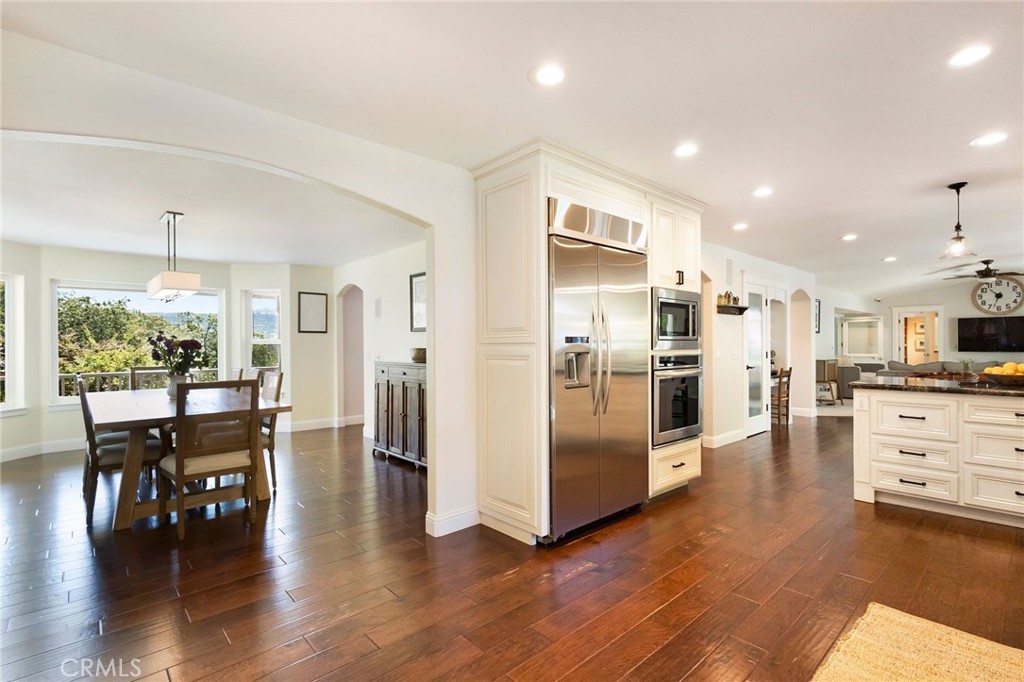 3731 Royal Mountain Road Oroville, CA 95965 - Photo 12 of 67 a kitchen with stainless steel appliances kitchen island granite countertop a refrigerator a stove a dining table and chairs with wooden floor
