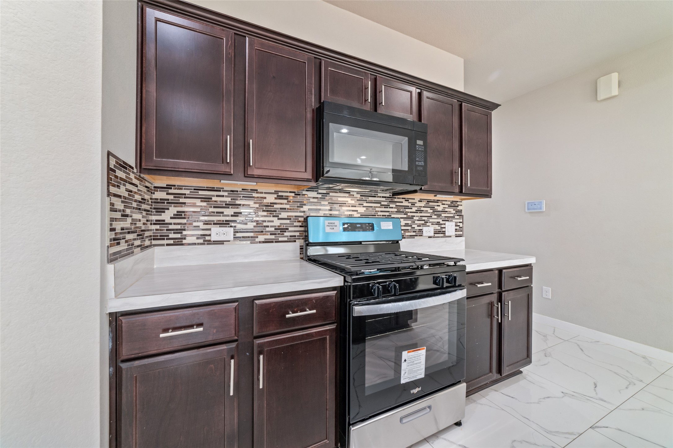 5502 Creekside Ridge Trail Katy, TX 77449 - Photo 10 of 25 a kitchen with granite countertop cabinets stove and microwave