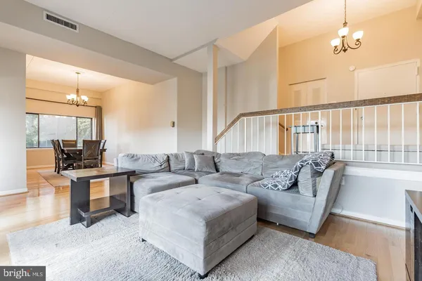 a living room with furniture a large window and a chandelier