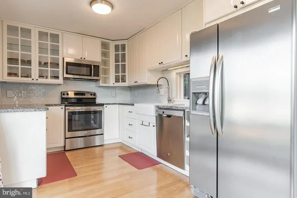 a kitchen with stainless steel appliances a refrigerator sink and microwave