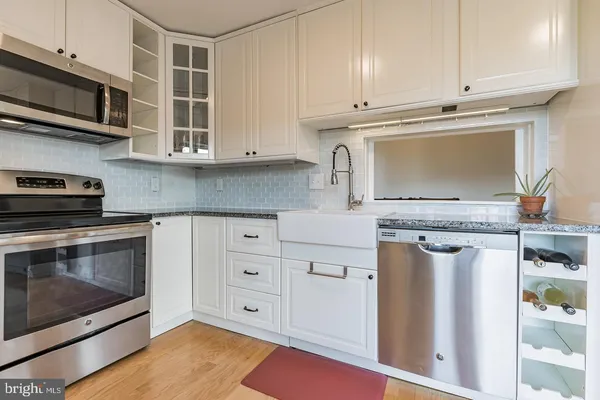 a kitchen with stainless steel appliances granite countertop a stove and a microwave